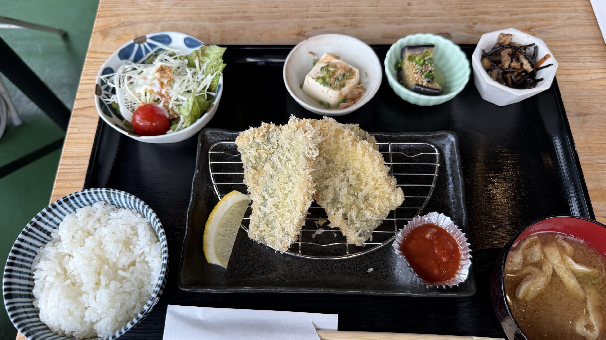 鋸南食堂の網に盛られたアジフライ。ご飯、味噌汁、サラダと三つの小鉢が並ぶお盆